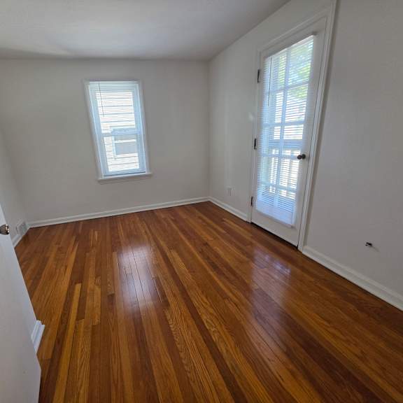 a room with wooden flooring and a window.