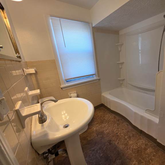 a white sink in a bathroom with a window.