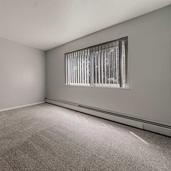 a room with a carpeted floor and a window with bars on it. at integrity berea apartments, berea, 44017