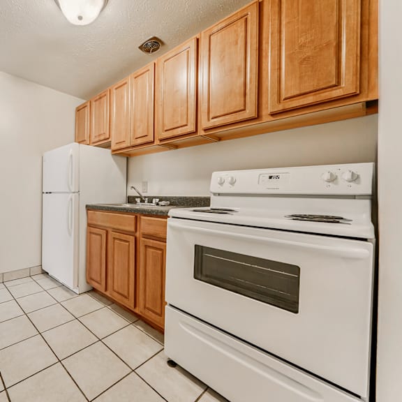 a kitchen with white appliances and wooden cabinets. at integrity berea apartments, ohio, 44017