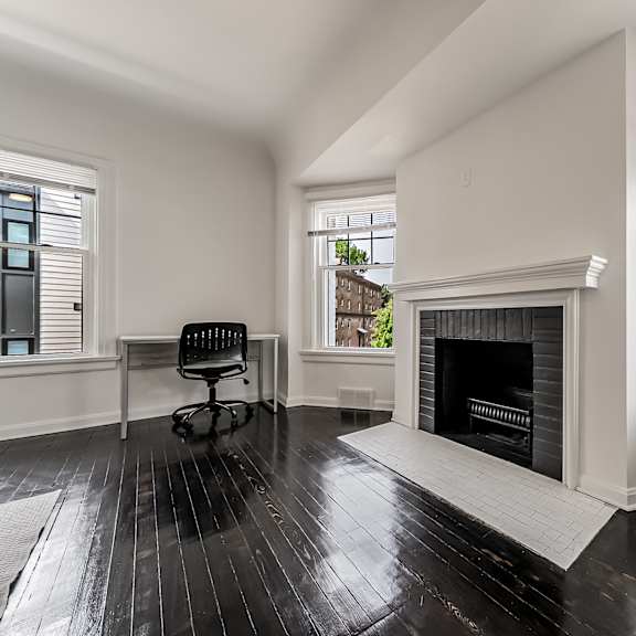 a black and white room with a fireplace and a chair.