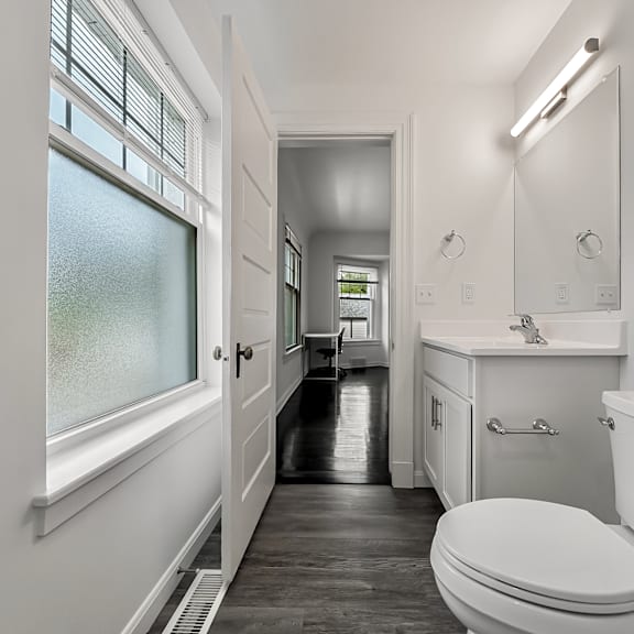 a white bathroom with a toilet, sink, and bathtub.