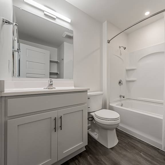 a white bathroom with a toilet, sink, and bathtub.