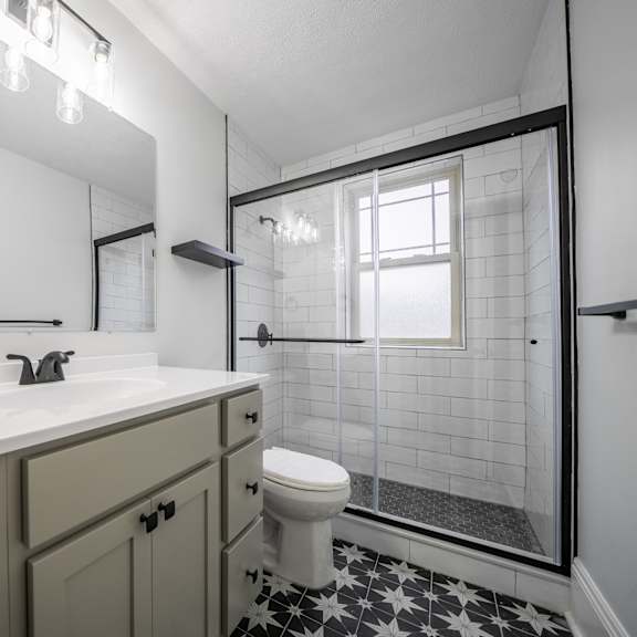 a white sink with a black and white tiled floor.at integrity cleveland heights apartments, cleveland heights
