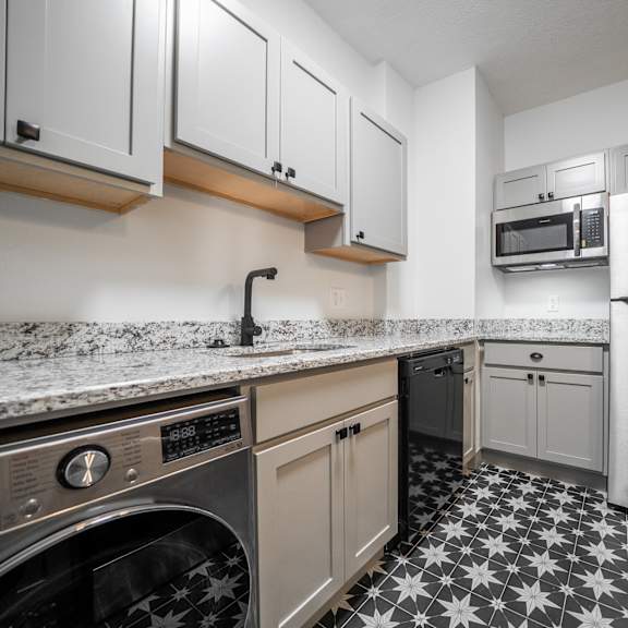 a kitchen with a black and white floor.at integrity cleveland heights apartments, cleveland heights, ohio