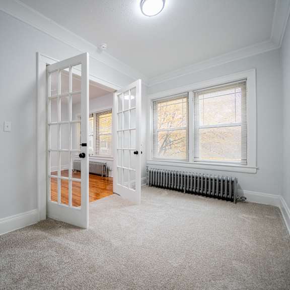 a room with a white door and a window with a radiator under the window.at integrity cleveland heights apartments, cleveland heights, oh