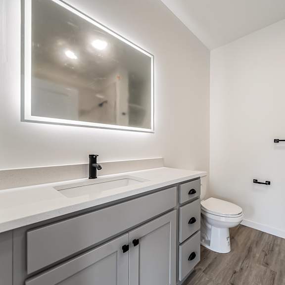 a bathroom with a white toilet and a sink with a mirror above it at westwood meadows, westlake, oh, 44145