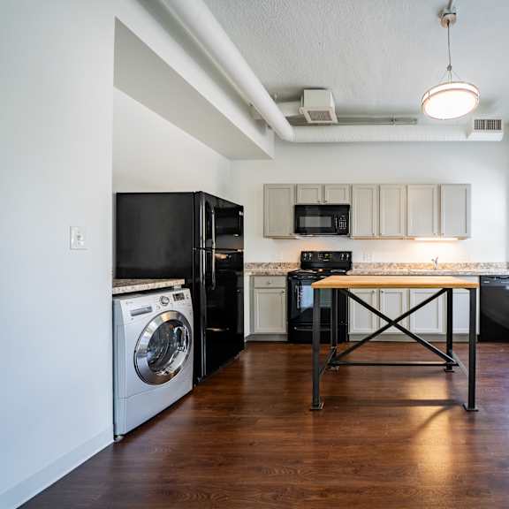 a kitchen with a black fridge and a black table.