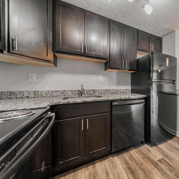a kitchen with black cabinets and a stainless steel refrigerator. at integrity berea apartments, berea, oh, 44017
