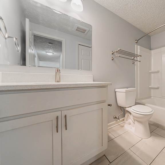 a white bathroom with a toilet, sink, and bathtub. at integrity berea apartments, berea, ohio