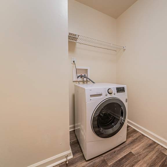 a washing machine is sitting in a corner of a room. at integrity berea apartments, ohio
