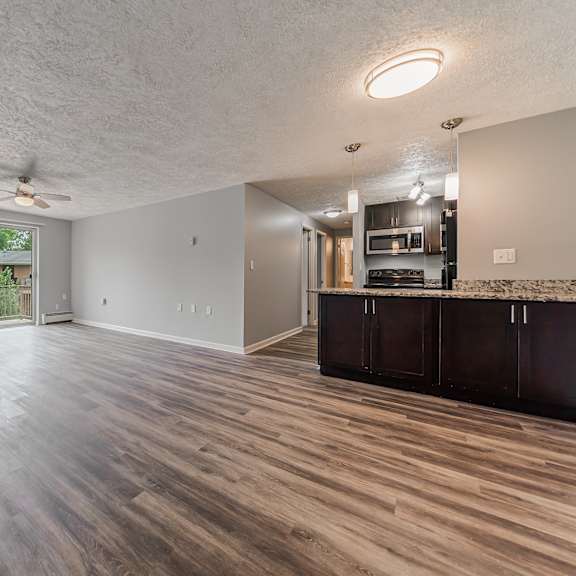 a spacious room with wood flooring and a ceiling fan. at integrity berea apartments, berea, ohio