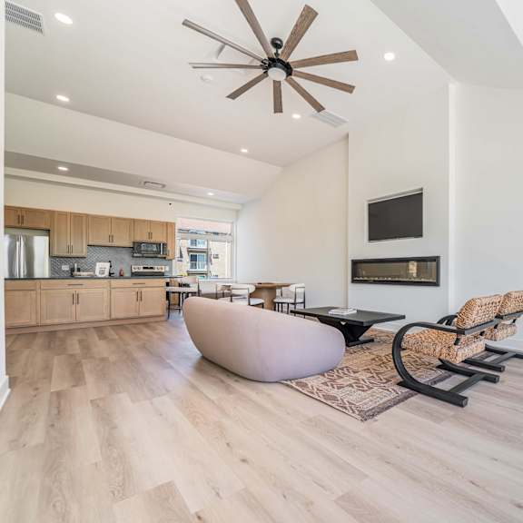 a modern living room with a brown ceiling fan and lighting.