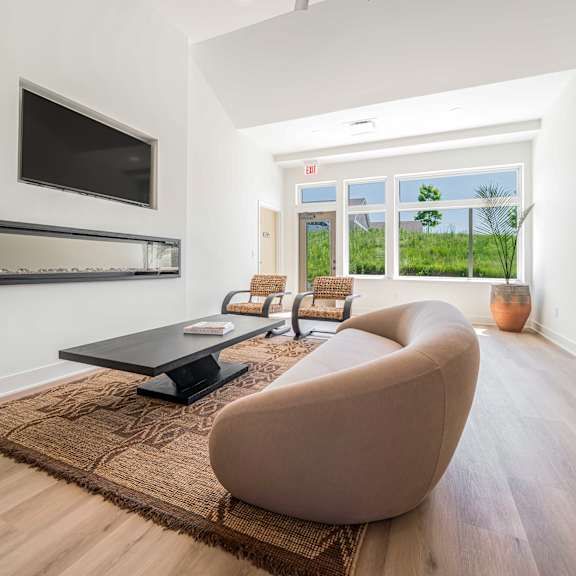 a modern living room with a brown chair and a black coffee table.