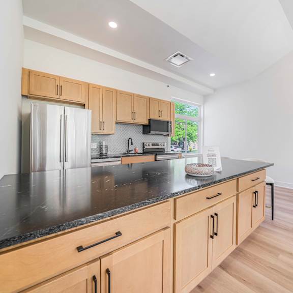 a kitchen with wooden cabinets and a black countertop.