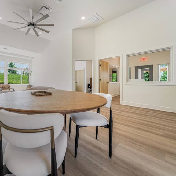 a dining room with a round table and chairs.