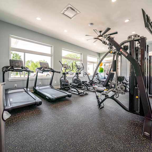 a spacious home gym with treadmills, elliptical machines, and other exercise equipment.