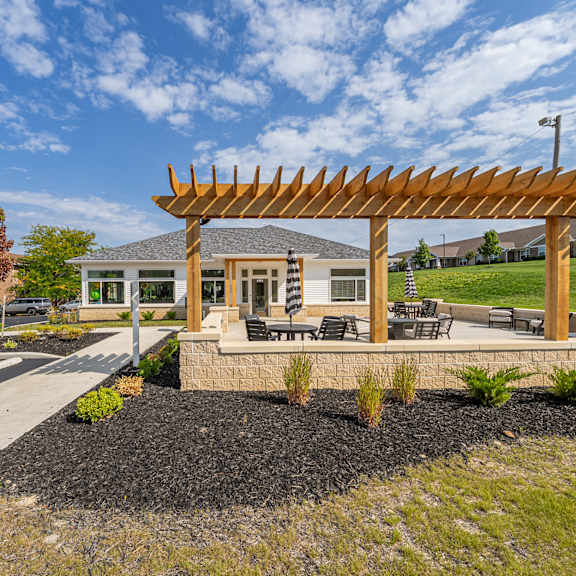 a wooden pergola is situated in the middle of a landscaped area.