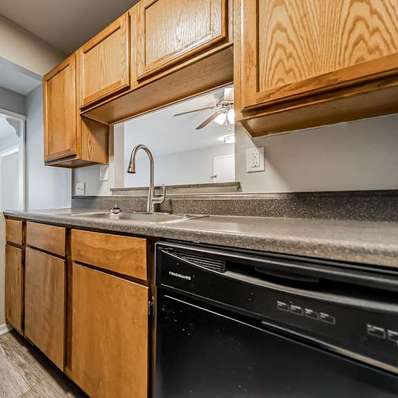 a kitchen with wooden cabinets and a black dishwasher at integrity chardon apartments, chardon,  ohio