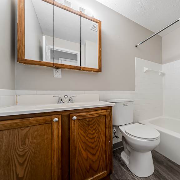 bathroom with white tub and wood cabinet at integrity chardon apartments, oh, 44024