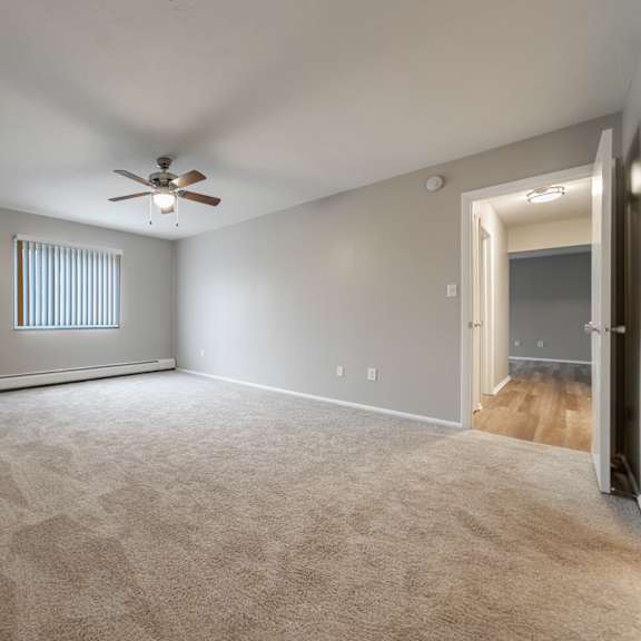 a room with a ceiling fan and carpeted floor.