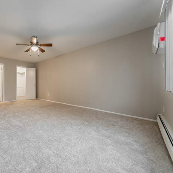 empty room with a ceiling fan and carpeted floor.