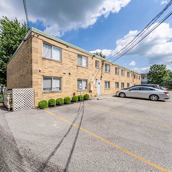 a parking lot with a building and a car.