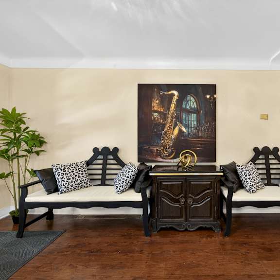 a living room with a sofa set and a painting on the wall.