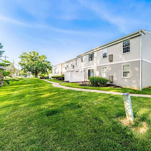 a residential building with a well-maintained lawn in front.