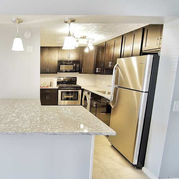 a kitchen with a granite countertop and stainless steel appliances. at integrity berea apartments, berea, ohio