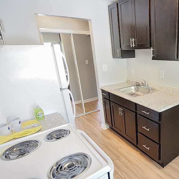 a kitchen with a white refrigerator, wooden cabinets, and a white stove top. at integrity berea apartments, ohio