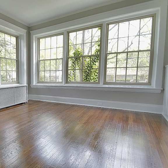 a room with a wooden floor and three windows at integrity gold coast apartments, ohio, 44102