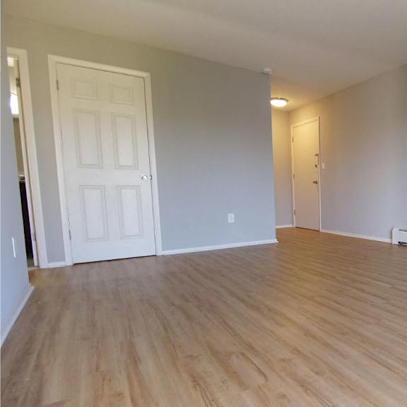 a living room with plank style flooring and a white door.