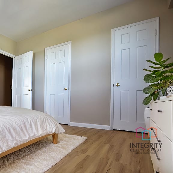 a bedroom with a large bed and a painting on the wall integrity realty, cleveland, oh, 44120