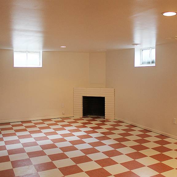 basement living area with checkerboard tile and fireplace