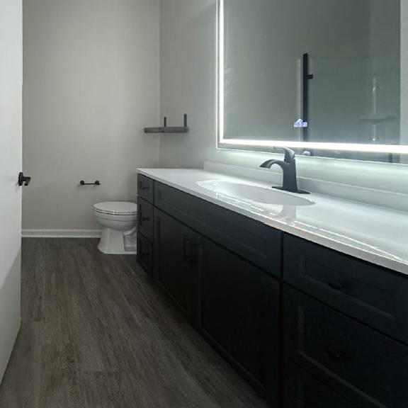 a bathroom with a toilet sink and mirror