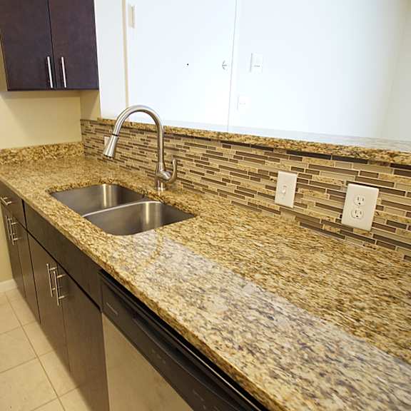 updated apartment kitchen island with granite counters and espresso cabinets.