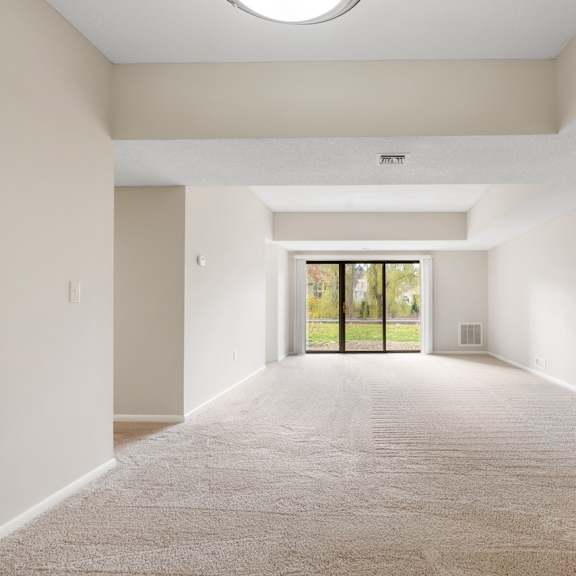 a spacious living room with sliding glass doors to a balcony.at atrium in the village, beachwood ohio