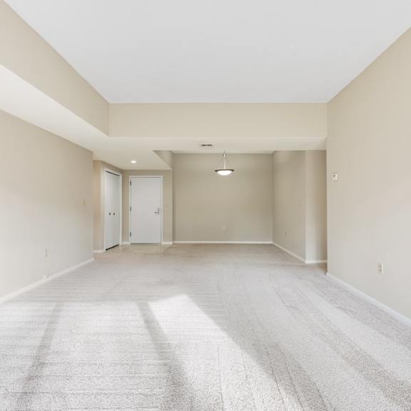 a spacious living room with a carpeted floor and white walls.at atrium in the village, ohio