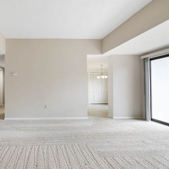 a large, empty room with a carpeted floor and a door on the left side.at atrium in the village, beachwood, oh 44122