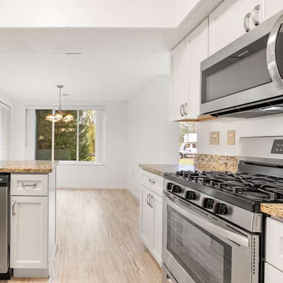 a kitchen with white cabinets and stainless steel appliances.at atrium in the village, beachwood