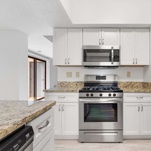a kitchen with a granite countertop and stainless steel appliances.at atrium in the village, ohio, 44122