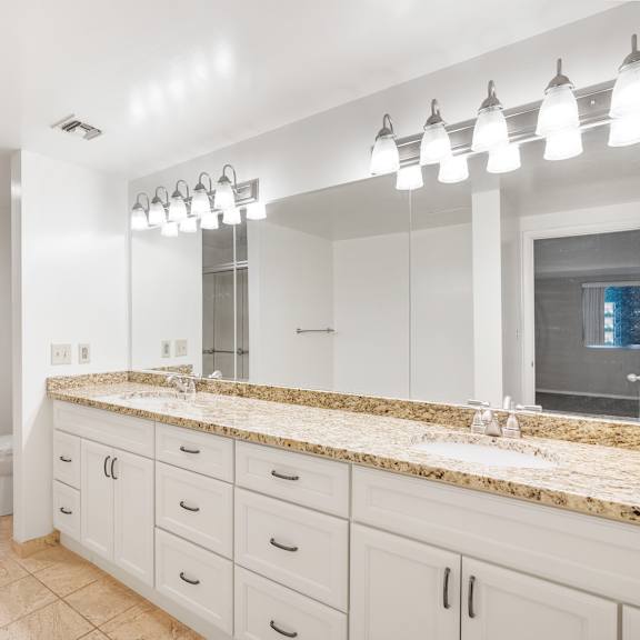 a bathroom with a marble countertop and a large mirror.at atrium in the village, beachwood, oh
