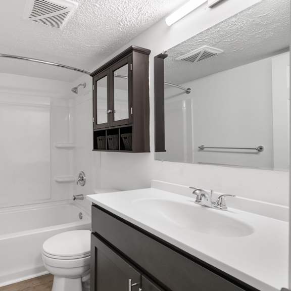 white bathroom with tub and espresso-colored cabinets at integrity medina apartments, medina, oh,  44256