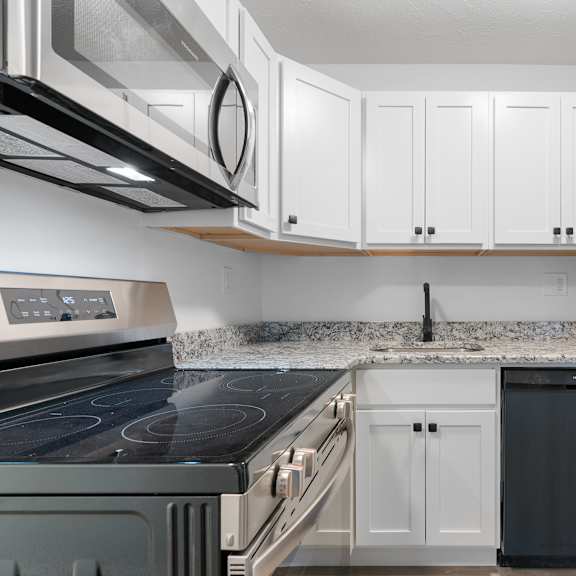 a kitchen with black appliances and white cabinets.