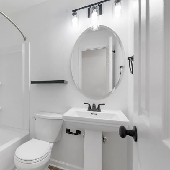 a white bathroom with a toilet, sink, and tub.