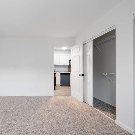 a large, empty room with a carpeted floor and white walls.
