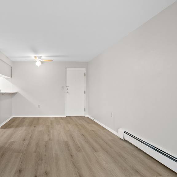 a room with wooden flooring and white walls.