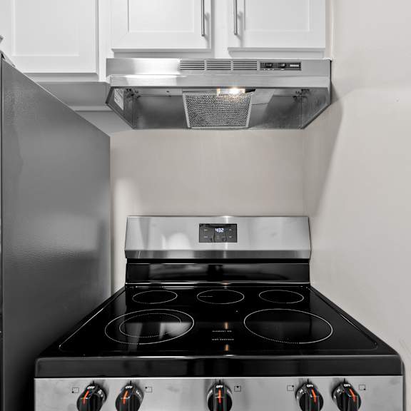 a modern kitchen with a stainless steel refrigerator and a black stove top.