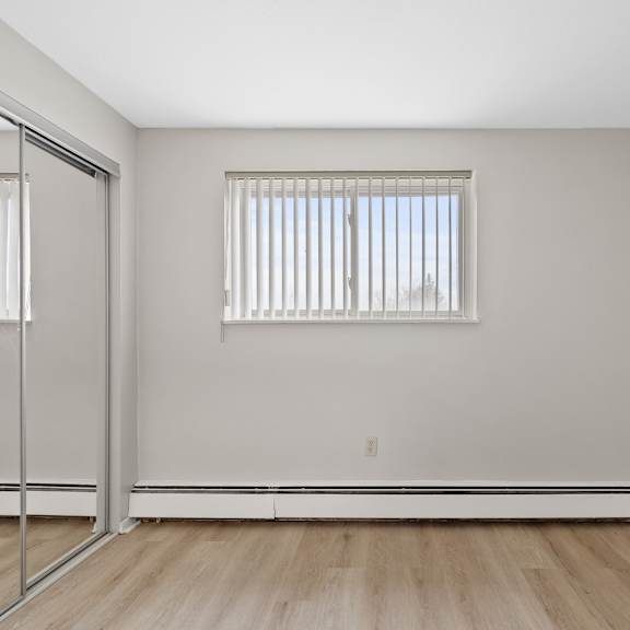 a bedroom with a mirrored closet.